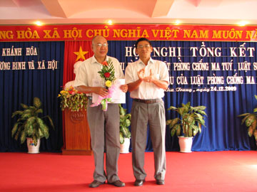 Mai Xuan Tri, Vice Director of Department of Labor, Invalids &amp; Social Affairs (right) rewards Prize A to a representative of Nha Trang City.