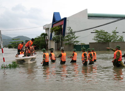 Officials and soldiers of Khanh Hoa Military Headquarters evacuate local people from flood-hit areas. 