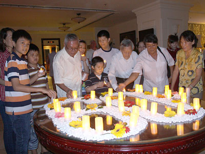 Guests in Sunrise Hotel lighting up candles set in the shape of 60+.