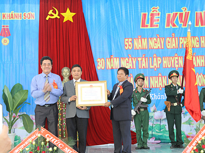 Le Thanh Quang (left) offers third-class Labor Medal to representatives of Khanh Son’s people and administration.