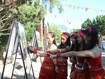 Young people in Khanh Son watching photos of local achievements.