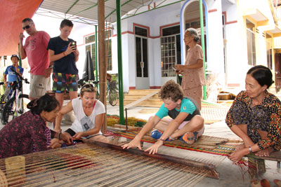 European tourists try to weave mat.