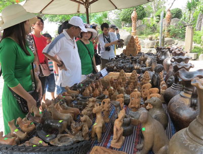 A lot of tourists visit and take souvenir photos at the booth of Bau Truc pottery.