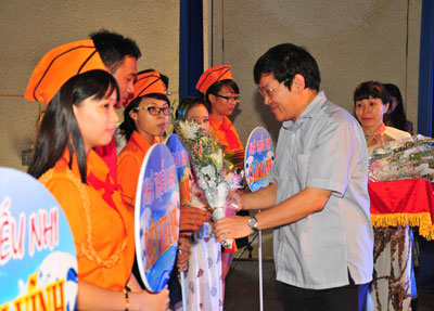 Nguyen Duy Bac giving souvenir flags and flowers to teams.