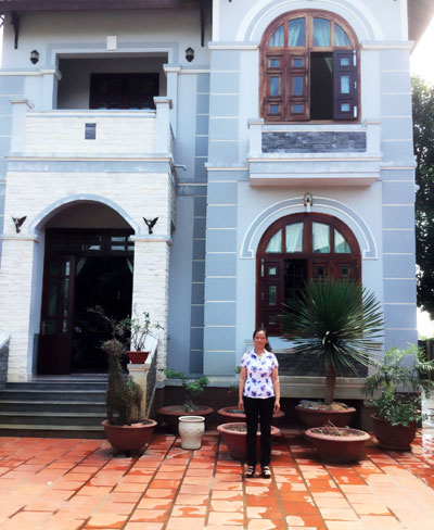 Nguyen Thi Gia by her spacious house. 