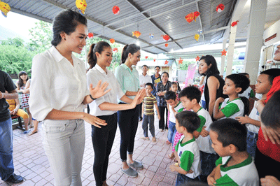 Beauty queen Pham Thi Huong (middle) and the two runners-up visit orphans. 