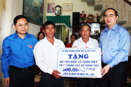 Nguyen Thien Nhan, Chairman of Central Committee of Vietnam Fatherland Front, giving financial support to a fisherman in Khanh Hoa.