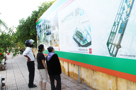 Nha Trang locals watching planning posted in Tran Phu Street