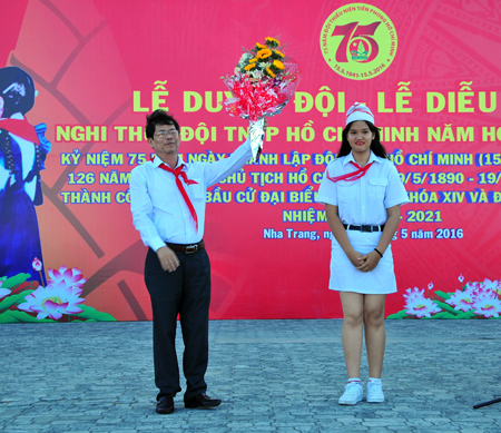 Representative of young pioneers offering flower to Nguyen Tan Tuan.