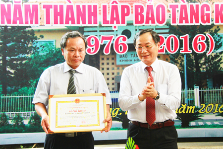 Nguyen Dac Tai (right) offering certificate of merit to leader of Khanh Hoa Museum.