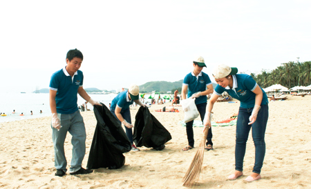 Muong Thanh Luxury Nha Trang Hotel's staff collecting garbage on Nha Trang beach