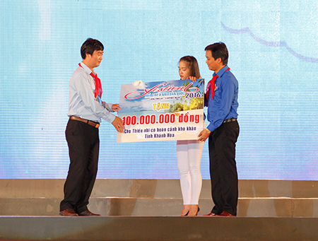 Representative of Central Council of Young Pioneer Organization giving scholarship for needy children to Khanh Hoa Provincial Youth Union’s representative (left).