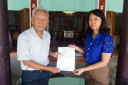 Leader of Khanh Hoa Provincial State Records Management and Achieves Department (right) giving document of Khanh Hoa Provincial People’s Committee on approving rare and precious documents of Phu Xuong Communal House.