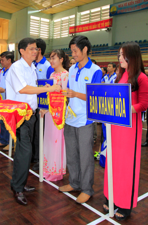 Nguyen Tan Tuan offering souvenir flags to participants.