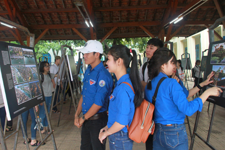 Students of Nha Trang University contemplating photos.