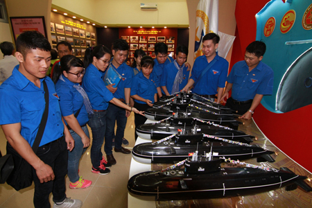 Youth Union members of Ho Chi Minh City Youth Union contemplating submarine models.