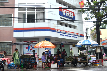 People selling “bánh chưng” (square glutinous rice cakes) and “bánh tét” (cylindrical glutinous rice cakes) at the corner of Thong Nhat Street and Le Thanh Phuong Street. 