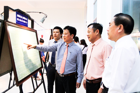 Representatives contemplating object displayed at exhibition.