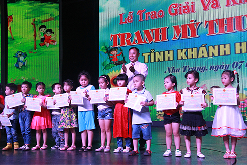 Le Van Hoa awarding gold prizes to preschool children.