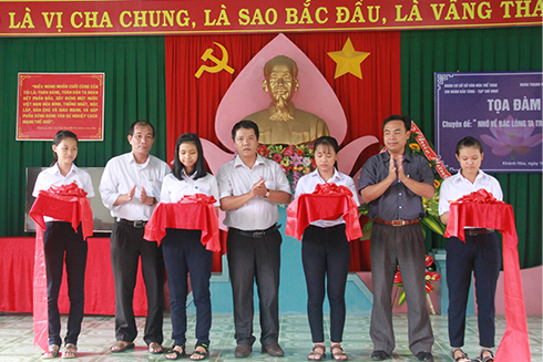 Cutting ribbon to open exhibition.