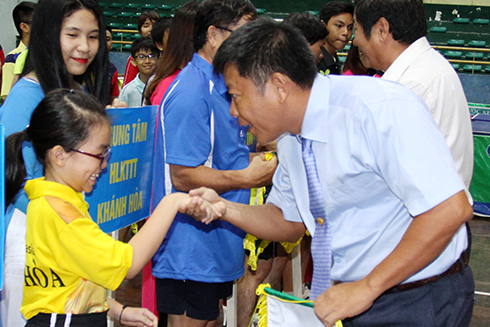 Representative of organization committee giving souvenir flag to teams.