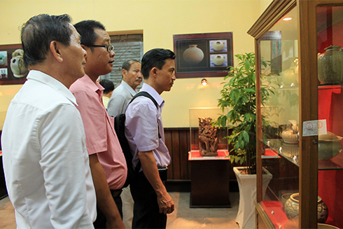 Representatives contemplating displayed objects.