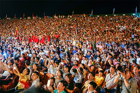 Stand is crowded with spectators.