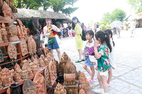 Tourists contemplating pottery products,…