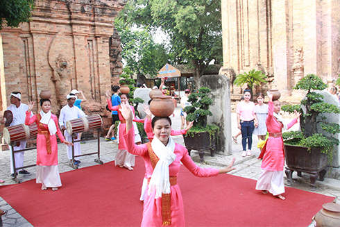 Cham women performing traditional dance with small pottery jars.