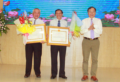 As mandated by the State President, Nguyen Dac Tai offered National Awards to songwriter Hinh Phuoc Long (left) and screenwriter Nguyen Si Chuc.