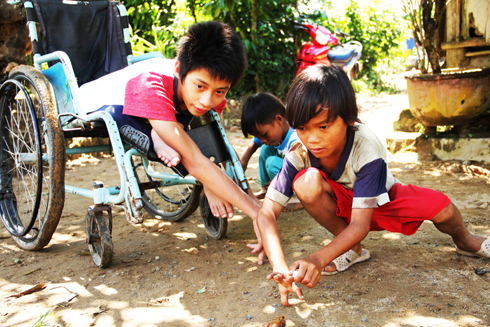 Children in Khanh Son playing marbles.