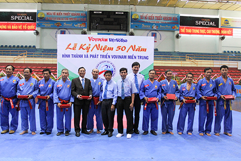 Representatives of Vietnam Vovinam Federation giving crystal plaques to masters.