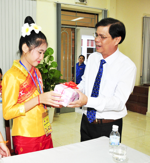 Nguyen Tan Tuan offering present to Laotian children.