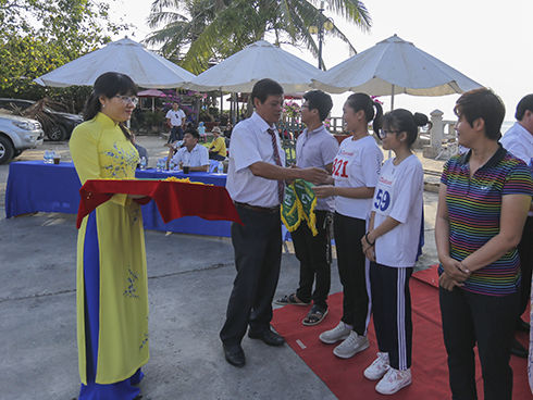 Representative of organization board gives commemorative flags to teams