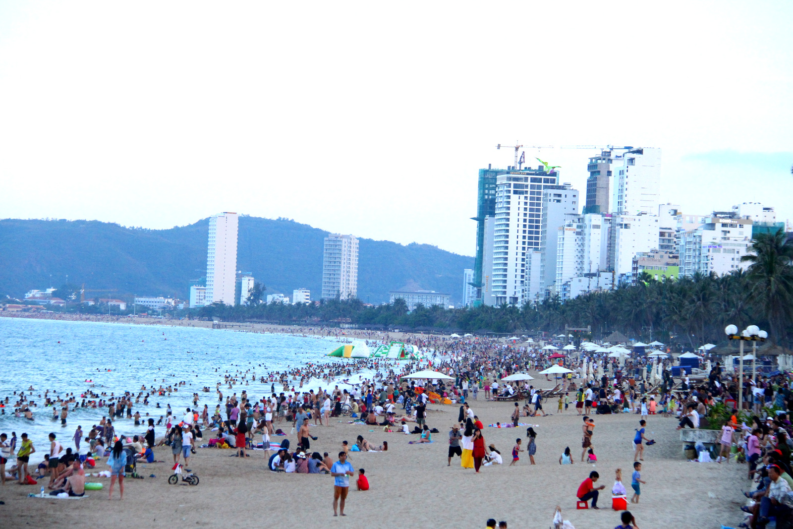 Numerous locals and tourists flock to Nha Trang beach to escape heat