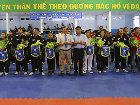 Organization committee offering commemorative flags to teams.