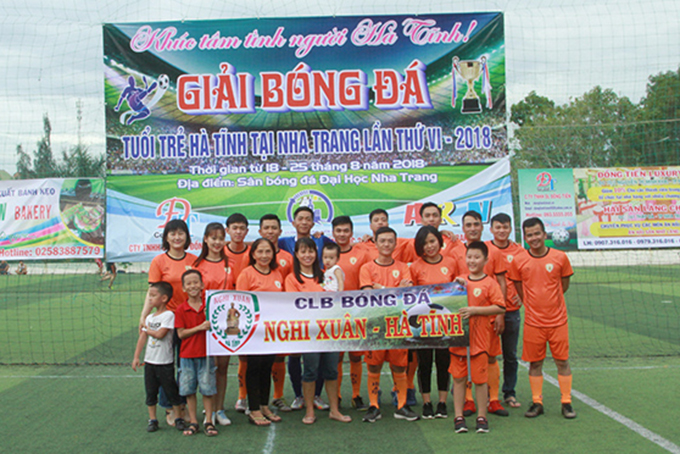 A team posing with supporters 