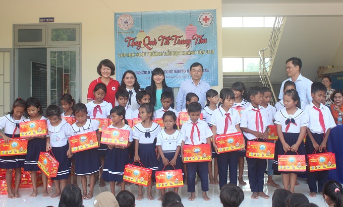 Representatives of Khanh Hoa Salanganes Nest Company and Khanh Hoa Red Cross offering Mid-autumn gifts to the pupils