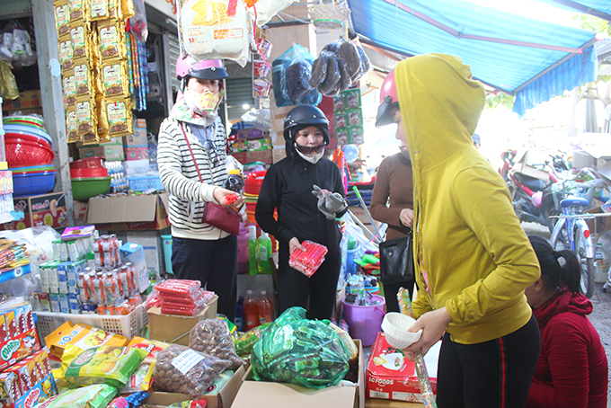 People buy candles and noodles at market