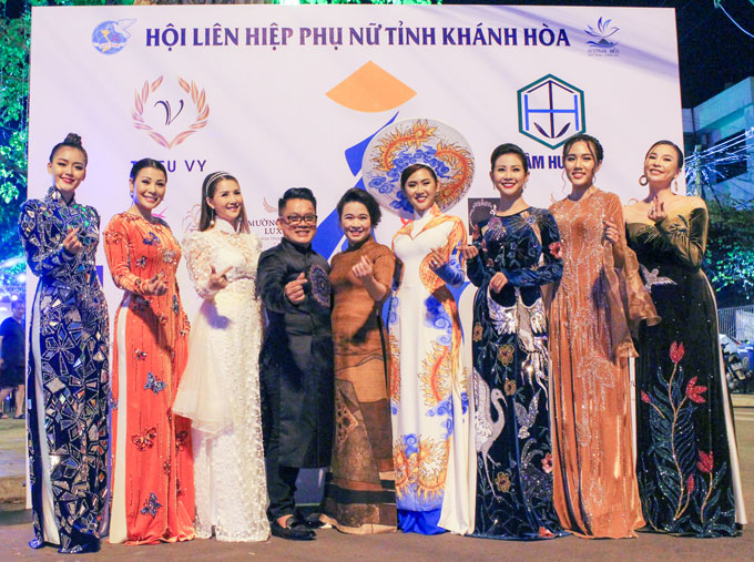 Designer Thieu Vy (fourth from left) posing for photograph with beauty queens and models