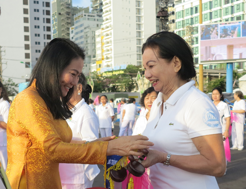 Nguyen Thi Thanh Huong, member of Executive Committee of Vietnam Federation of UNESCO Associations, offering commemorative flags to participating groups