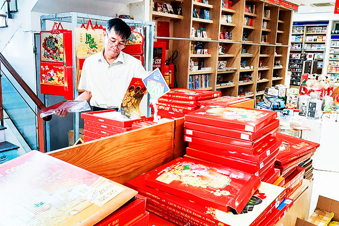 Customer contemplating Tet calendars at Phuong Nam Bookstore