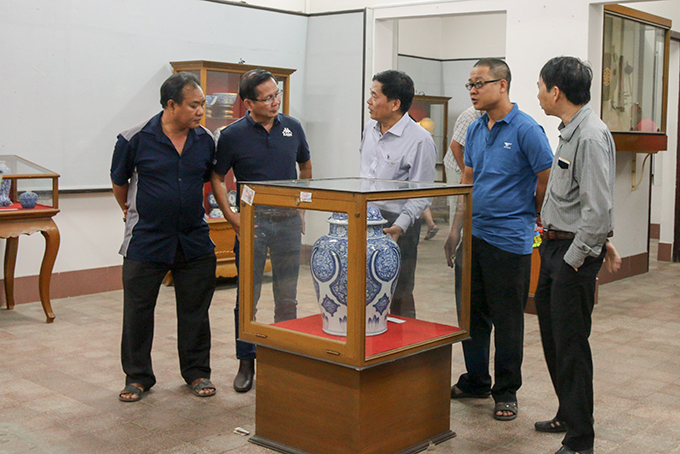 Visitors contemplating antiques