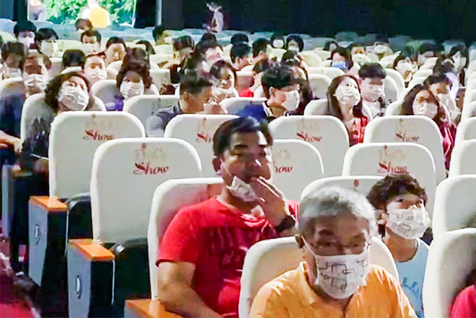 Tourists wearing mask watching art show at Legend Theatre