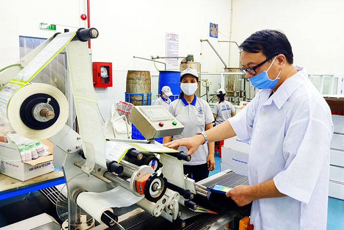 Vuong Vinh Hiep checking products before packing