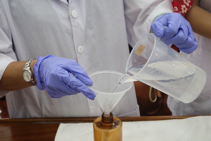 Pouring sanitizer into bottle