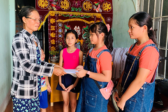 Sisters Nguyen Linh Chi and Nguyen Phuong Khanh (students of Singapore Vietnam International School) offering their piggy bank saving to Ngoc Anh and Hoang Nhan 