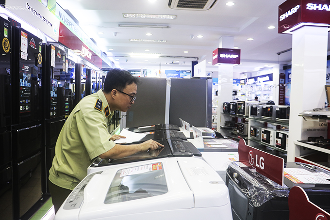 Market management staff checking electrical and household goods