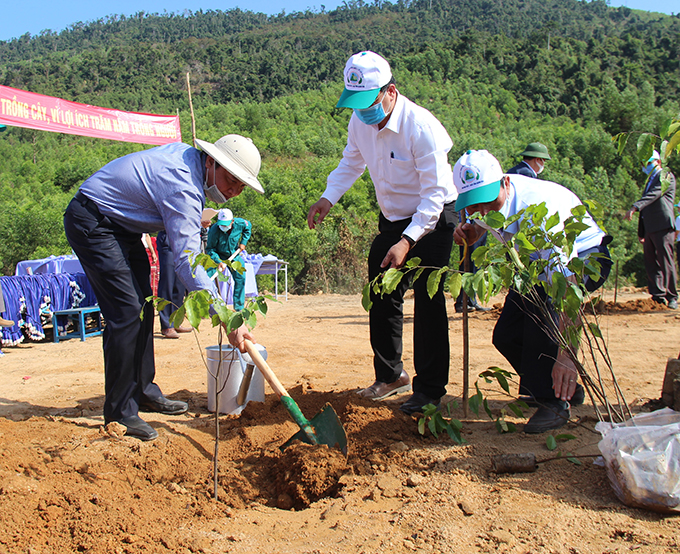 Nguyen Khac Dinh (left) plants trees at launching ceremony