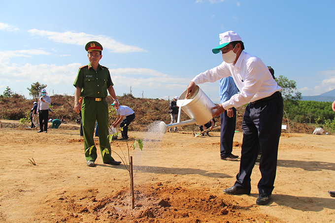 Tran Ngoc Thanh watering newly-planted tree